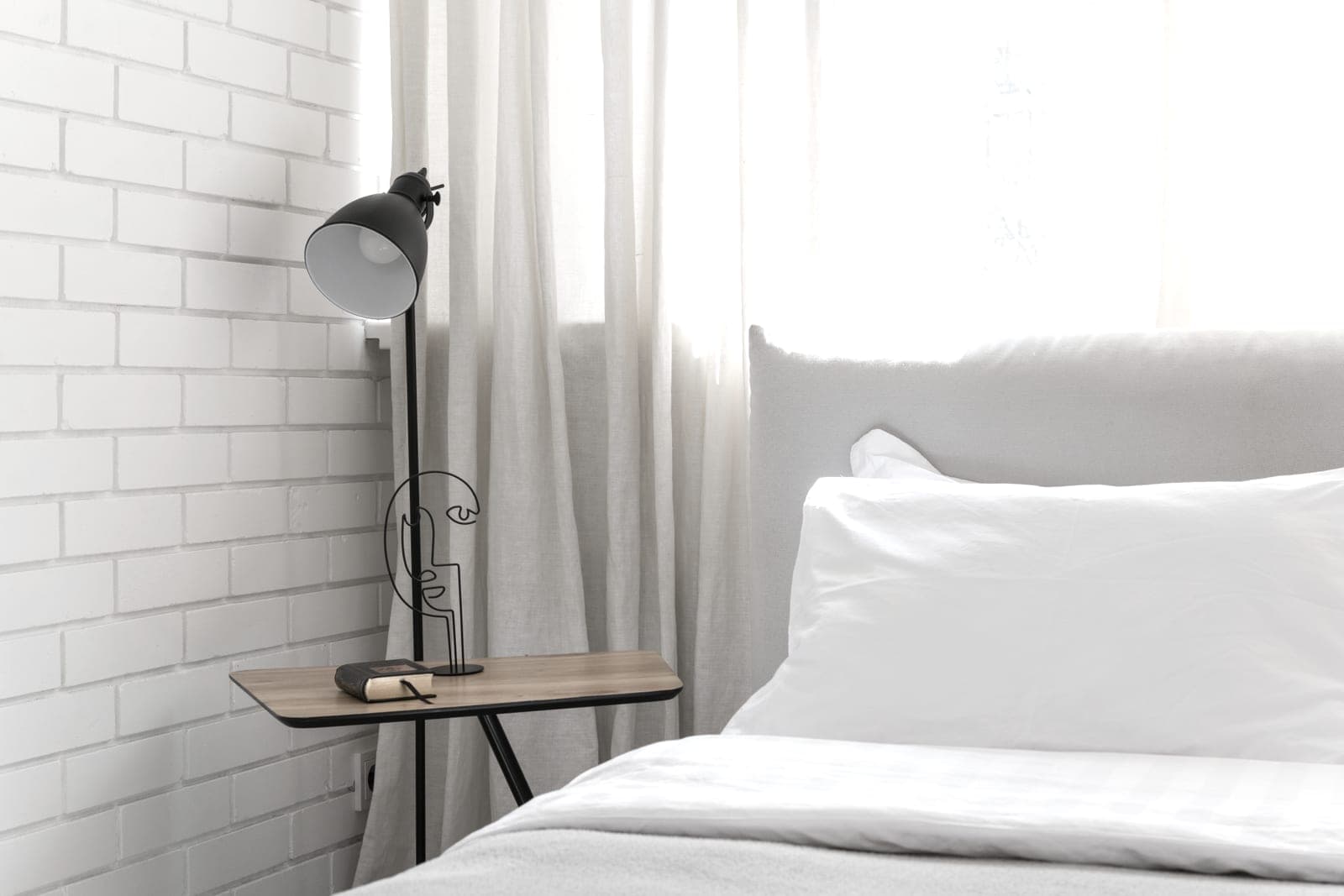 A calm bedroom with white bedding in soft morning light