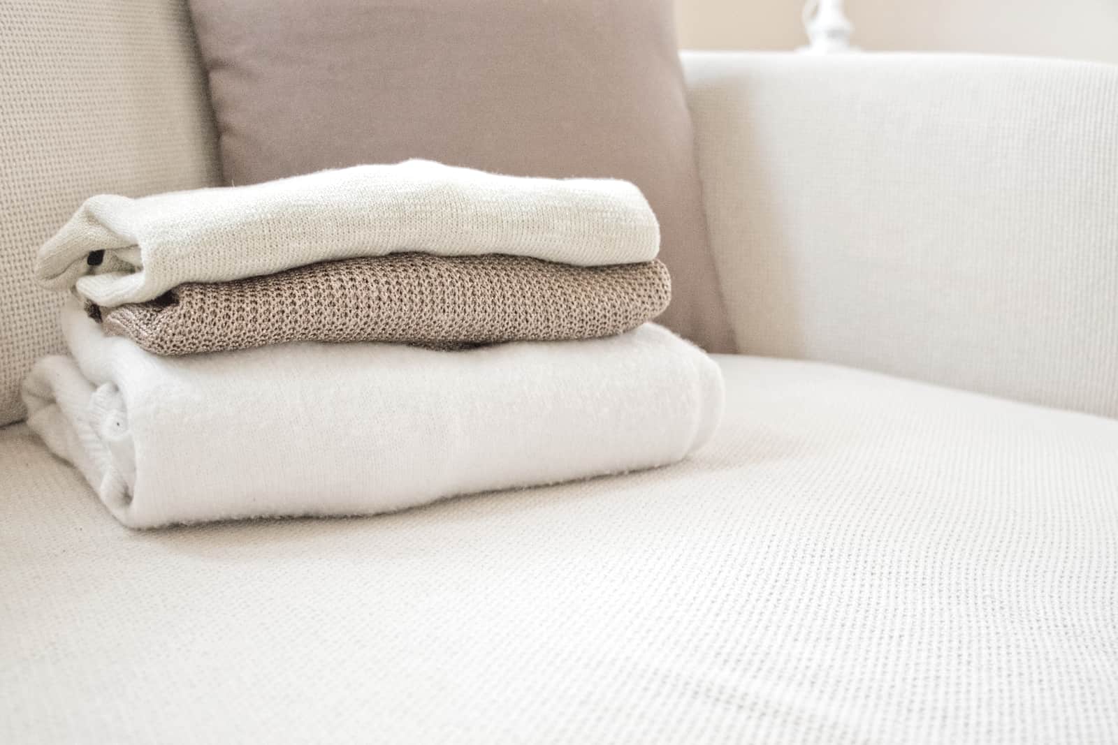 A folded wool blanket resting on a made bed