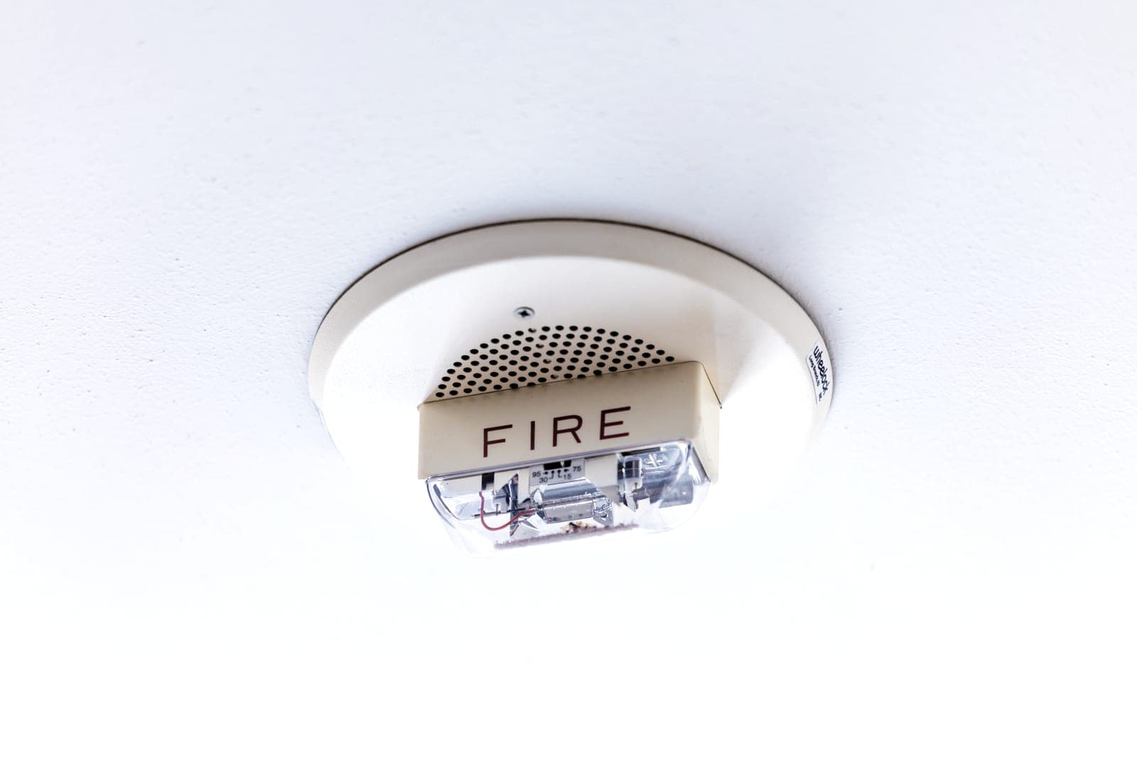 A smoke alarm mounted on a white ceiling
